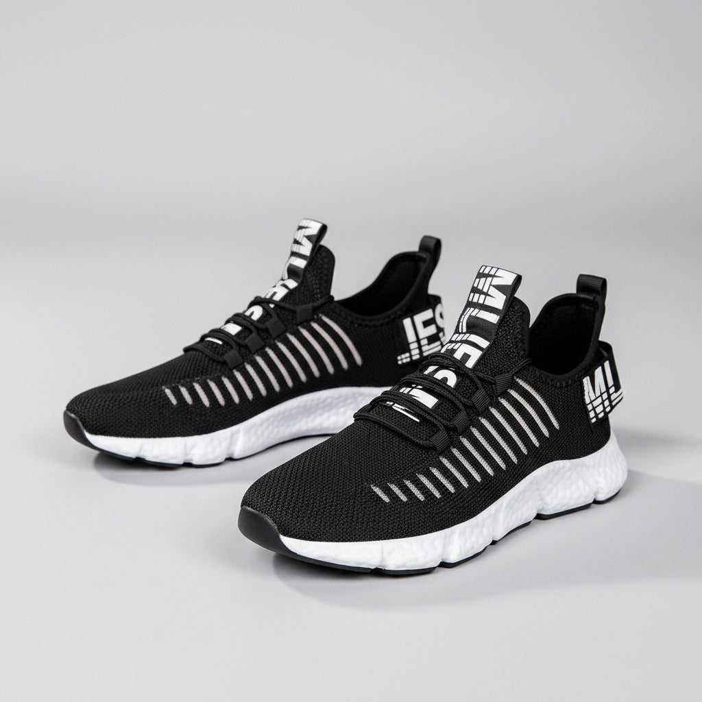 Black and white athletic shoes worn by a person on a wooden floor.