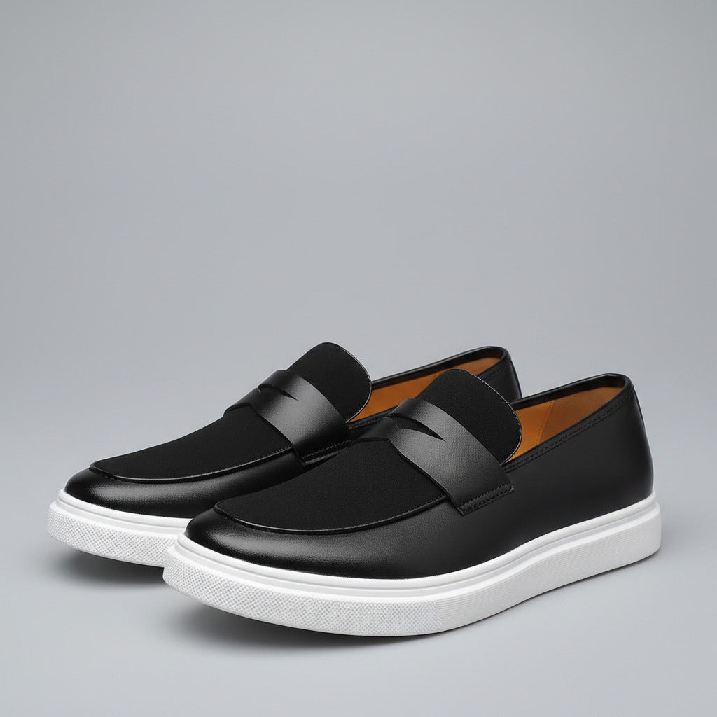 Black loafers with white soles on a wooden surface