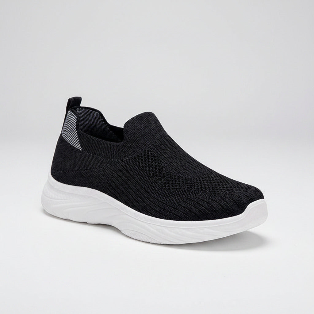 Black slip-on sneaker with white sole on a white background