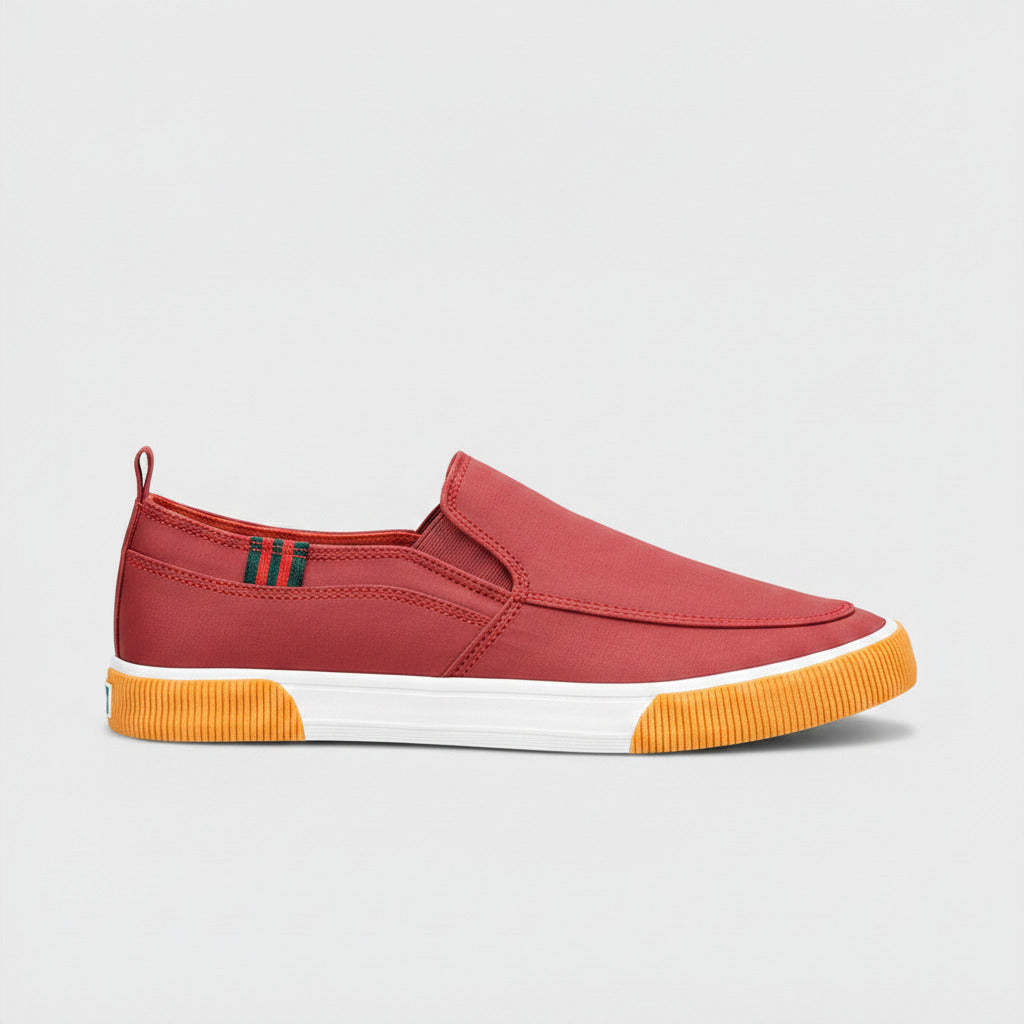 Red slip-on shoe with orange sole on a white background