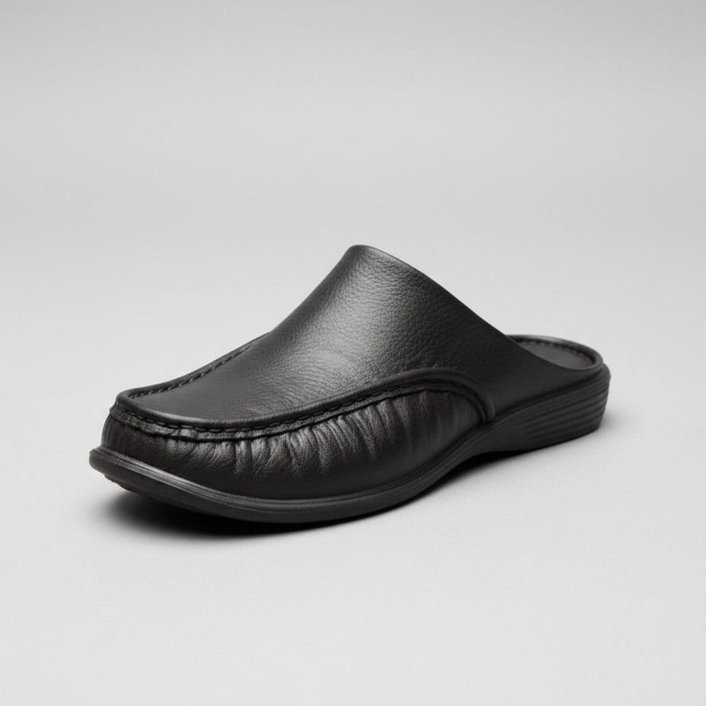 Black leather slippers worn on a stone pavement