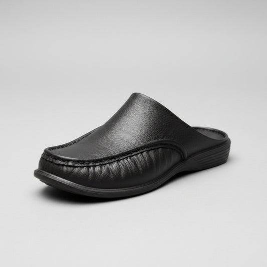 Black leather slippers worn on a stone pavement