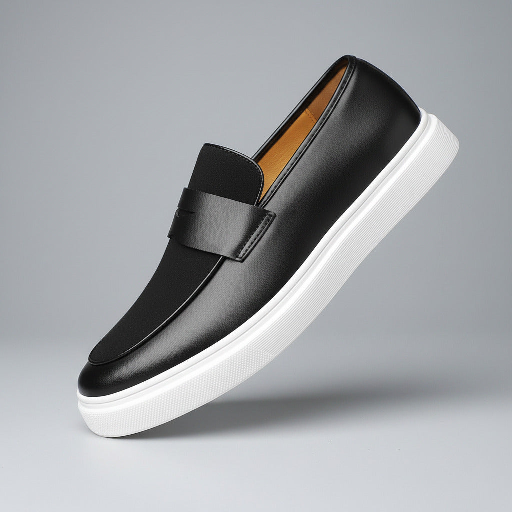 Black loafer shoe with white sole on a wooden surface