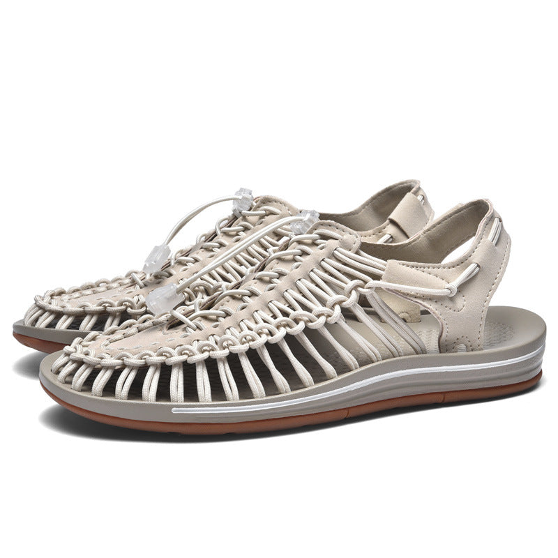 Pair of beige sandals with woven design on a white background