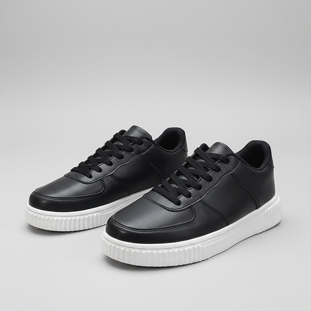 Black sneakers with white soles on a reflective surface