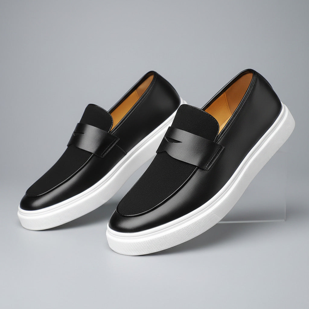 Black loafers with white soles on a wooden surface