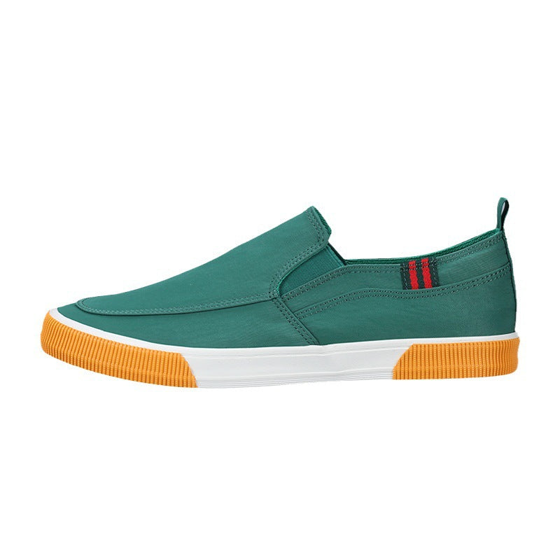Green slip-on shoe with orange sole on a white background