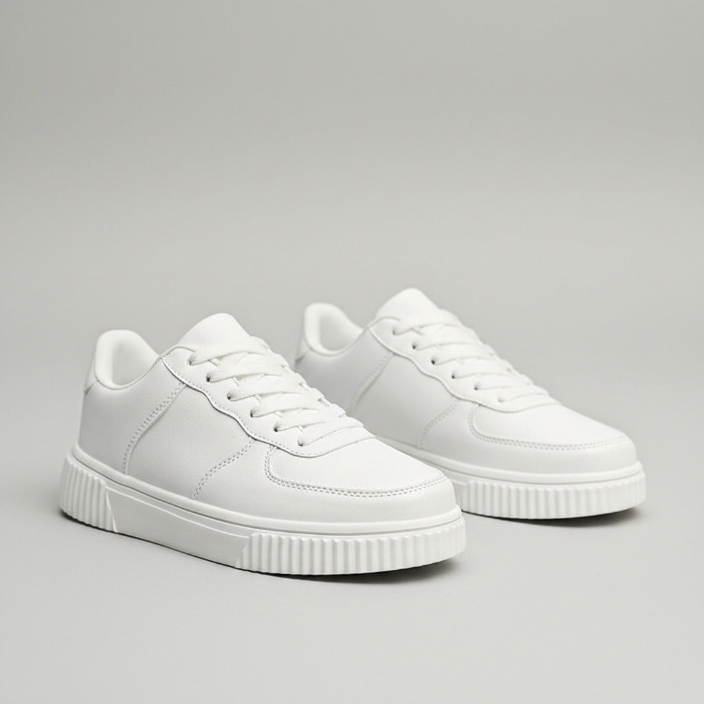 White sneakers on a gray surface with a blurred background