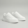 White sneakers on a gray surface with a blurred background