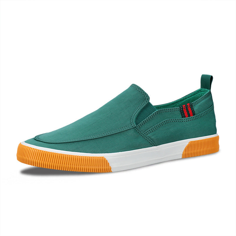 Green slip-on shoe with orange sole on a white background