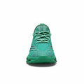 Green sneaker with unique sole design on a white background