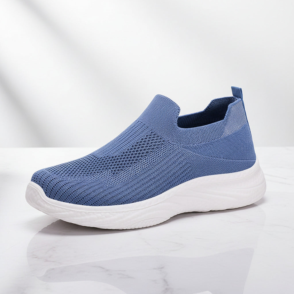 Blue slip-on sneaker with white sole on a white background